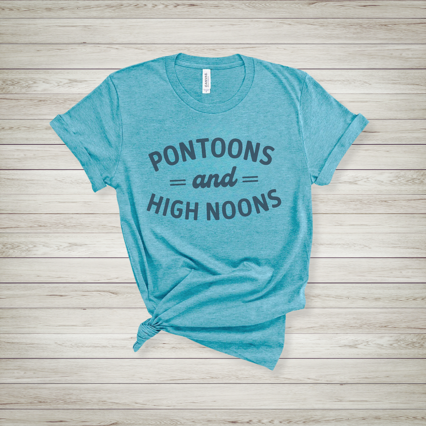 Blue t-shirt with 'Pontoons and High Noons' text on a wooden surface